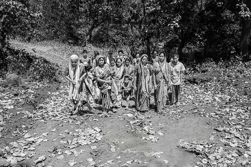 A PVTG community proudly walking along the unpaved road constructed by them to facilitate the driving of a truck-mounted drilling rig to their habitation in Gumla district, Jharkhand, India